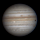 A probable impact flash on Jupiter, seen just off center.